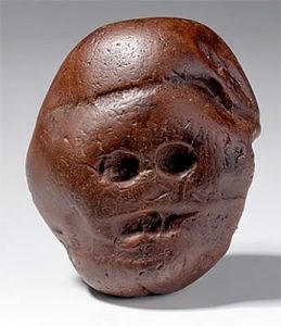 Makapansgat cobble, a naturally shaped jasperite stone resembling a human face, thought to have been carried by an Australopithecine from a distant source site in South Africa.